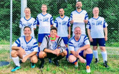 Die Fussballmannschaft WILUX SPRINTER, bestehend aus Mitarbeitern der WILUX PRINT, posiert gemeinsam auf dem Spielfeld des Hinwiler Dorfturniers. Das Team nahm am Turnier teil, unterstützt von Freunden und Familie.