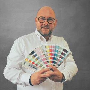 Fernando Migliore, Mitglied des Team WILUX PRINT und Technischer Verkäufer in der Abteilung Media, professionell gekleidet in einem weissen Hemd vor einem neutralen Hintergrund.