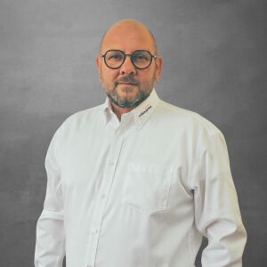 Peter Demuth, Technischer Verkäufer Media bei WILUX PRINT, hält einen Pantonefächer in den Händen, professionell gekleidet in einem weissen Hemd vor einem neutralen Hintergrund.