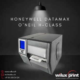 Honeywell Datamax O'Neil H-Class Hochleistungsindustriedrucker beleuchtet durch einen Spotlichtstrahler, mit blauem LCD-Display und ausgegebenen Etiketten, vor einem dunklen Hintergrund, flankiert von WILUX PRINT Kontaktinformationen