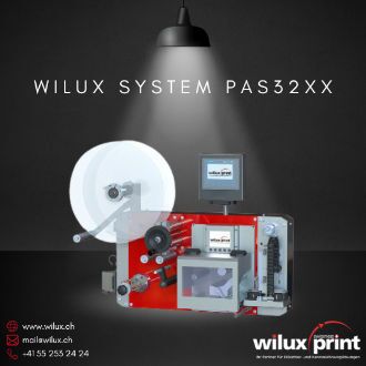 Etikettieranlage WILUX System PAS32XX mit einer Rollenhalterung und einem Inline-Thermotransferdrucksystem. Die Anlage ist ausgestattet mit einem Monitor für einfache Bedienung und Kontrolle.