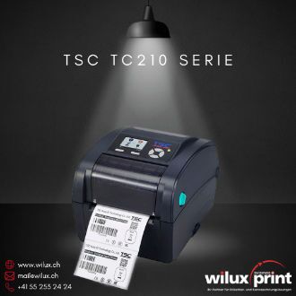 TSC TC210 Desktop-Etikettendrucker auf dunklem Hintergrund, beleuchtet von oben. Dunkles Design mit blauem Zierstreifen und einem Bedienfeld mit Display an der Vorderseite. Ein Barcode-Etikett wird gedruckt. WILUX PRINT Kontaktinformationen unten.