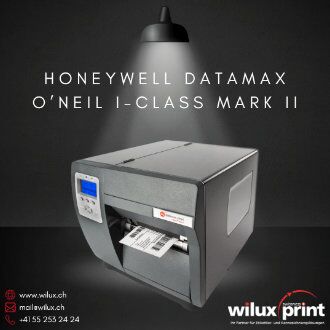 Honeywell Datamax O'Neil I-Class Mark II, ein zuverlässiger Barcodedrucker, zeigt seine Druckfähigkeit mit sichtbaren Etiketten, beleuchtet von oben und präsentiert auf einem dunklen Untergrund mit WILUX PRINT-Informationen