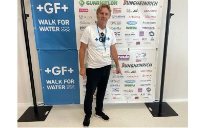 Fredy Fischbacher, Leiter Media bei WILUX PRINT, steht vor einem Sponsor-Banner des „Walk for Water 2023“ von Georg Fischer. Die Veranstaltung zielt darauf ab, das Bewusstsein für den Zugang zu sauberem Wasser zu stärken.