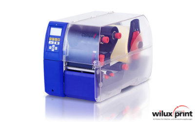 Carl Valentin Compa V label printer in blue-silver with control panel, display, and transparent view of the roll mechanism, symbolizes intuitive operation and high quality
